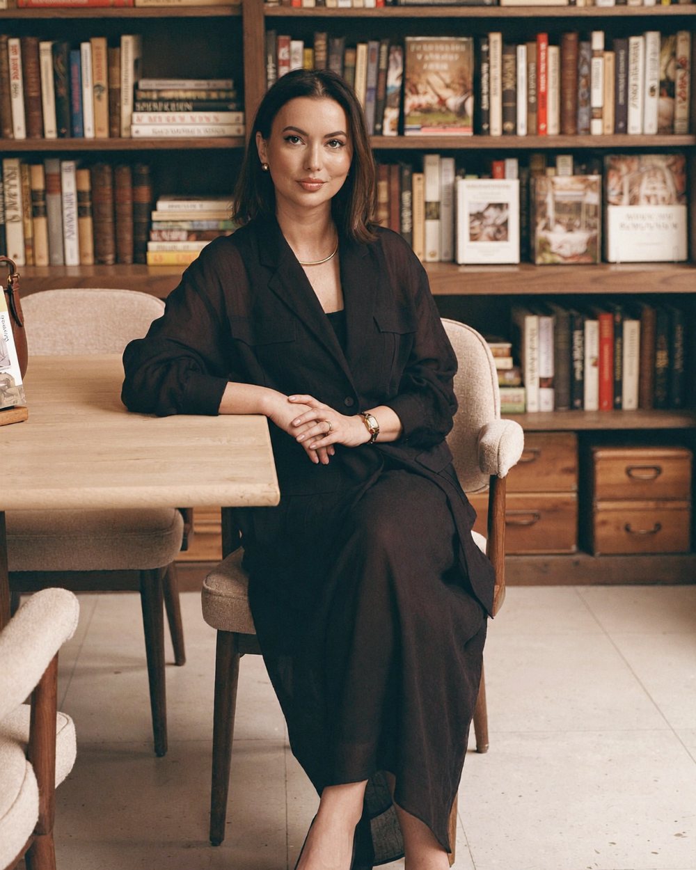 Anna Aleshko, AI-powered creative director, sitting at a table in a library