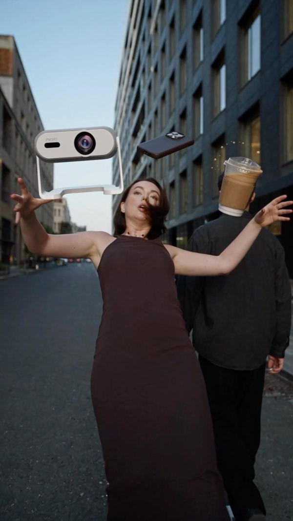 Woman dancing in a city street with a man whose head is a coffee cup